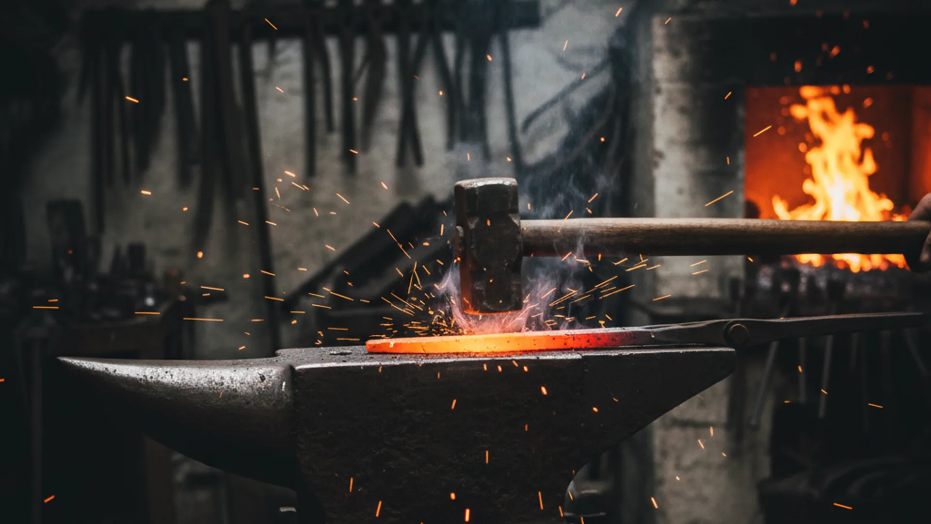 Forgeron travaillant l'acier incandescent sur une enclume dans son atelier